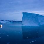 In this Aug. 15 photo, a boat navigates at night next to large icebergs in eastern Greenland. Rising temperatures and diminished snow and ice cover in the Arctic are imperiling ecosystems, fisheries and local cultures, according to a report issued Tuesday, Dec. 10 by the National Oceanic and Atmospheric Administration. (AP Photo/Felipe Dana, File)