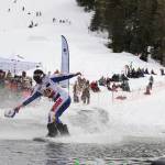 A snowboarder stays afloat onto the skim pond at Eaglecrest Ski Area as they partake in the return of the Slush Cup Saturday afternoon. (Clarise Larson / Juneau Empire)