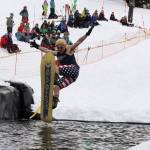 A snowboarder leaps onto the skim pond at Eaglecrest Ski Area as they partake in the return of the Slush Cup Saturday afternoon. (Clarise Larson / Juneau Empire)