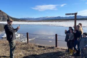 Ryan Becker, a teacher at the Eagle school, takes a photo of his students as part of a continuing Yukon River ice study on May 12, 2023. (Courtesy Photo / Ned Rozell)