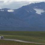A trucker drives the Dalton Highway toward Prudhoe Bay beneath the withering Gates Glacier. (Photo by Ned Rozell)