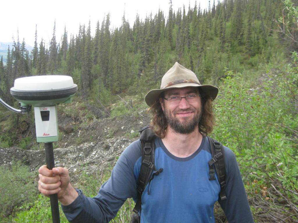 Ronnie Daanen measures the movement of a frozen debris lobe off the Dalton Highway north of Coldfoot in 2014. (Photo by Margaret Darrow)