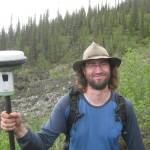 Ronnie Daanen measures the movement of a frozen debris lobe off the Dalton Highway north of Coldfoot in 2014. (Photo by Margaret Darrow)