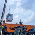 A crane unloads a car from a used gondola after its arrival in Juneau last year. Eaglecrest Ski Area officials say they are hoping the gondola will be operational by the 2025-26 winter ski season. (Photo courtesy of Eaglecrest Ski Area)