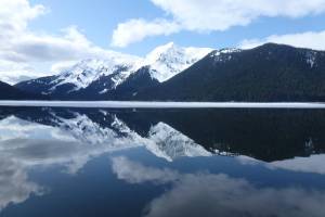 The sky and mountains are reflected in the water on April 5, 2012, at the Kootznoowoo Wilderness in the Tongass National Forests Admiralty Island National Monument. Conservation organizations bought some private land and transferred it to the U.S. Forest Service, resulting in an incremental expansion of the Kootznoowoo Wilderness and protection of habitat important to salmon and wildlife. (Photo by Don MacDougall/U.S. Forest Service)