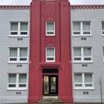 A raven perches atop the three-story Art Deco entry of The Assembly, a reinforced concrete apartment building constructed in 1932. (Laurie Craig / Juneau Empire)