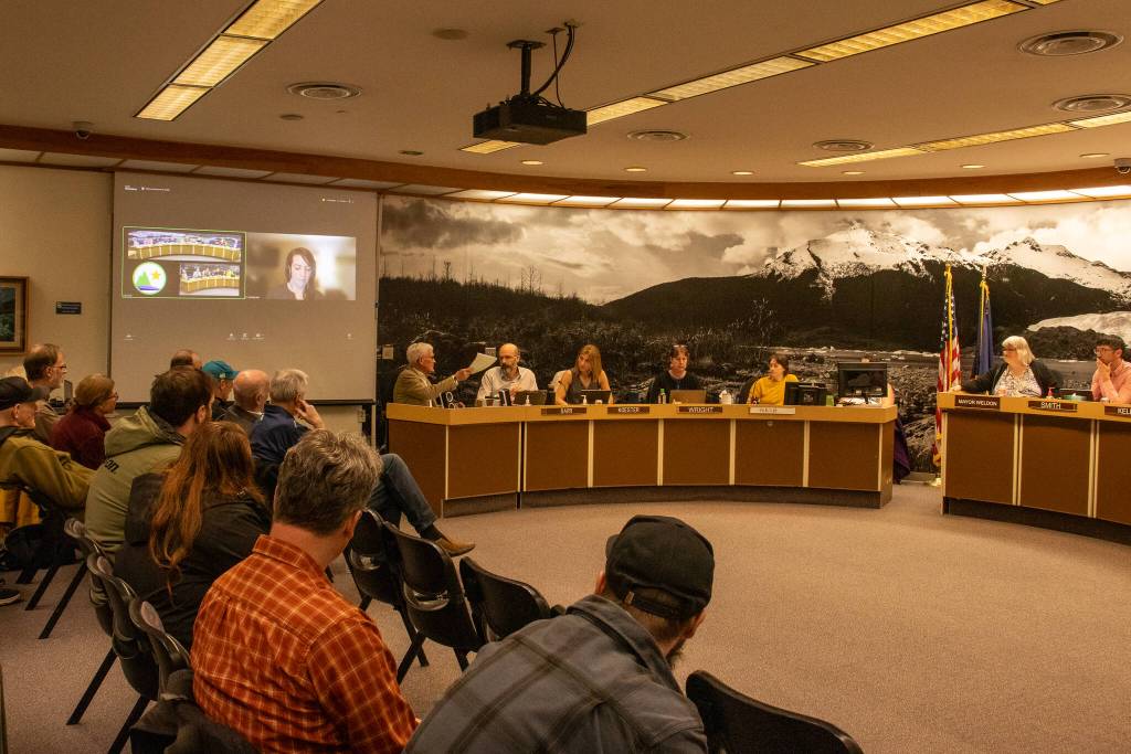 Bill Leighty, a downtown resident, hands his proposed amendments to the Juneau Assembly on Monday, April 7, 2025. (Jasz Garrett / Juneau Empire)