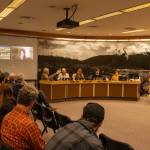 Bill Leighty, a downtown resident, hands his proposed amendments to the Juneau Assembly on Monday, April 7, 2025. (Jasz Garrett / Juneau Empire)