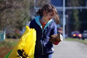 Gerald Thill, 7, inspects a weathered can before placing it in a litter bag during the annual citywide cleanup in 2023. (Ben Hohenstatt / Juneau Empire file photo)