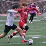 Juneau-Douglas High School: Yadaa.at Kalé senior defender Reed Maier (19) marks an attack by West Anchorage senior Noah Robinson during the Crimson Bears 1-1 tie with the Eagles on Friday at Adair Kennedy Memorial Park. (Klas Stolpe / Juneau Empire)