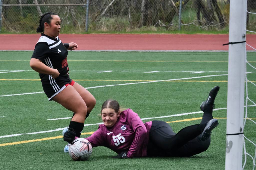 Juneau-Douglas High School: Yadaa.at Kalé senior Milina Mazon slips a shot past Soldotna sophomore keeper Ryan Queen (55) during the Crimson Bears 2-1 loss to the Stars on Thursday at Adair Kennedy Memorial Park. JDHS was ruled offside and the goal was disallowed. (Klas Stolpe/ Juneau Empire)