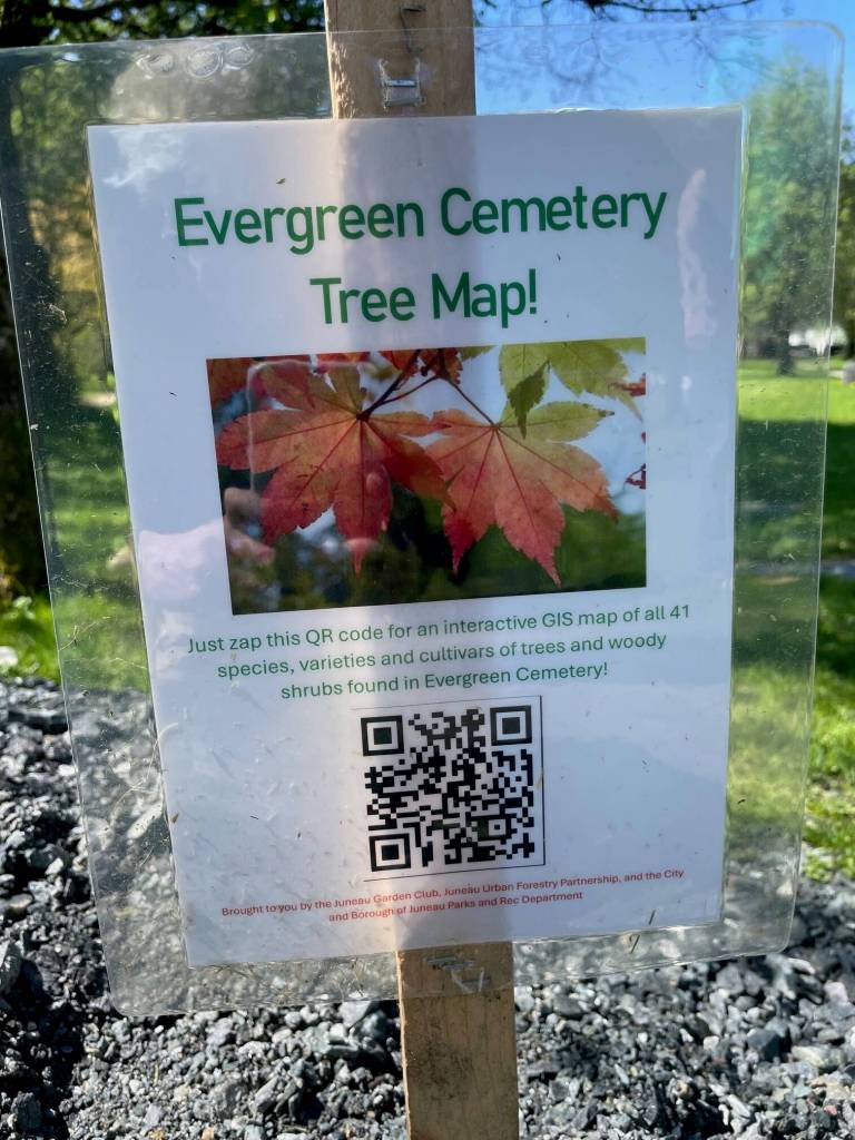 A sign at Evergreen Cemetery features a QR code that links to a digital map showing where more than 100 donated trees can be located. (Laurie Craig / For the Juneau Empire)