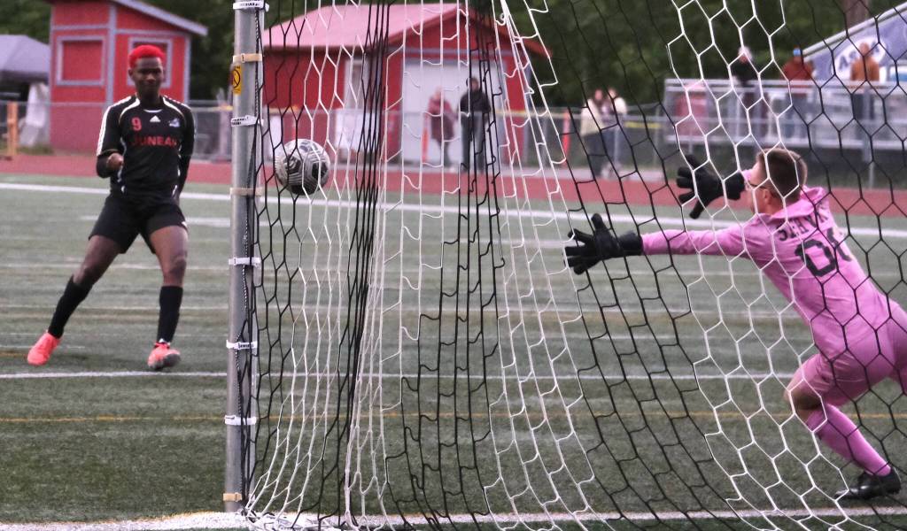 Juneau-Douglas High School: Yadaa.at Kalé senior Ahmir Parker (9) hits a penalty shootout past Service sophomore keeper Nathaniel Thate (00) during the Crimson Bears 1-1 (5-4) win over Service to open the 2025 ASAA/First National Bank Alaska Soccer State Championships at Wasilla High School on Thursday, May 29, 2025. (Klas Stolpe / Juneau Empire)