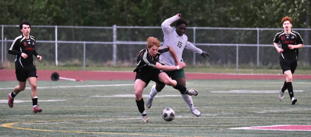 Juneau-Douglas High School: Yadaa.at Kalé senior Reed Maier battles with a Service player as teammates Kellen Chester and Erik Thompson (15) move into the play during the Crimson Bears win over Service to open the 2025 ASAA/First National Bank Alaska Soccer State Championships at Wasilla High School on Thursday, May 29, 2025. (Klas Stolpe / Juneau Empire)