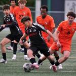 Juneau-Douglas High School: Yadaa.at Kalé sophomore Sonny Mazon (2) works a ball away from West Anchorage juniors Luca Driscoll (6) and Adoum Abakaarabdou (8) during the Crimson Bears 3-2 loss to the Eagles on Friday in the 2025 ASAA/First National Bank Alaska Soccer State Championship semifinals at Wasilla High School. (Klas Stolpe / Juneau Empire)