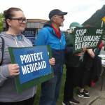 Demonstrators hold signs outside state senators offices on Friday, June 27, 2025. (Natalie Buttner / Juneau Empire)