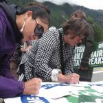 Megan Lingle writes a postcard to Alaska state senators on Friday, June 27, 2025. (Natalie Buttner / Juneau Empire)