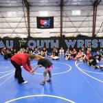 2024 Olympic wrestling gold medalist Amit Elor, 21, center, demonstrates a counter move on Anchorage fifth grader Pia Kopiasz, 10, during the Juneau Girls Wrestling Clinic on Wednesday at the Juneau Wrestling Center. (Klas Stolpe / Juneau Empire)