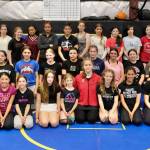 Wrestlers pose for photo at the Juneau Girls Wrestling Clinic on Wednesday at the Juneau Wrestling Center. The camp was led by 2024 Olympic Gold Medalist Amit Elor, kneeling at center front. (Klas Stolpe / Juneau Empire)
