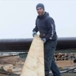 A Viking Lumber employee pulls lumber from the green chain after it has gone through the mill. (Courtesy of Viking Lumber Company)