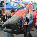 Salmonfest attendees accompany the Parkstrippers Marching Band through the Causeway, carrying a large salmon puppet, on Saturday, Aug. 2, 2025, at the Kenai Peninsula Fairgrounds in Ninilchik, Alaska. (Delcenia Cosman/Homer News)