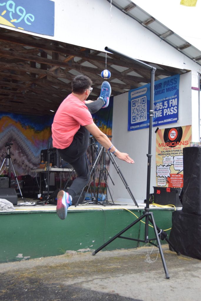 Dez Hess performs the 1-foot high kick during a Native Youth Olympics demonstration at the Inlet Stage on Saturday, Aug. 2, 2025, at the Kenai Peninsula Fairgrounds in Ninilchik, Alaska. (Delcenia Cosman/Homer News)