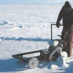 Lew Shapiro cuts into sea ice north of Utqiaġvik, then called Barrow, during his long career with the Geophysical Institute. (Photo courtesy of UAF Geophysical Institute)