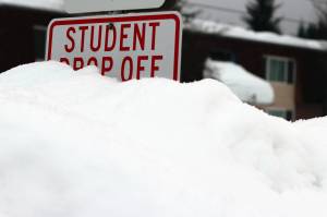 A mound of a snow obscures a "student drop off" sign near Sít' Eetí Shaanàx-Glacier Valley School. (Ben Hohenstatt / Juneau Empire file photo)
