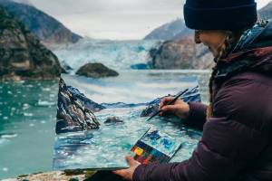 Photo courtesy of Paul Robbins. Claire Giordano paints a glacier using watercolors as the Tracy Arm Fords Terror Artist in Residency for 2024.