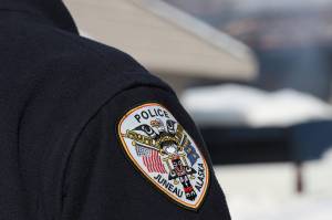 A Juneau police officer stands on duty in early March. (Clarise Larson/Juneau Empire File)