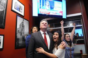 Republican gubernatorial candidate Mike Dunleavy reacts to early favorable election returns Tuesday, Nov. 6, 2018 In Anchorage, Alaska. With Dunleavy are from left, his wife Rose and daughters Ceil and Maggie. (AP Photo/Michael Dinneen)